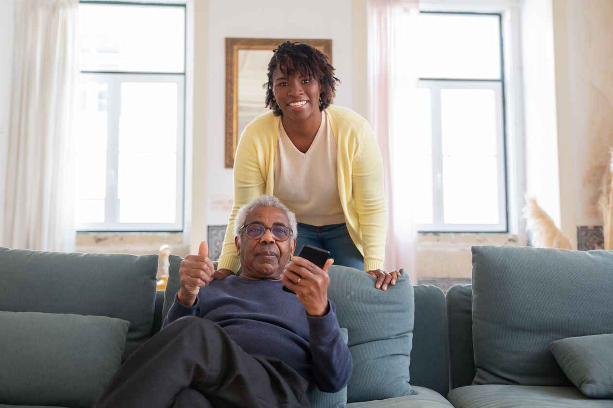 Smiling live-in caregiver spending quality time with an elderly man at home